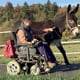 Foto: Barbara Bank im Rollstuhl mit Esel