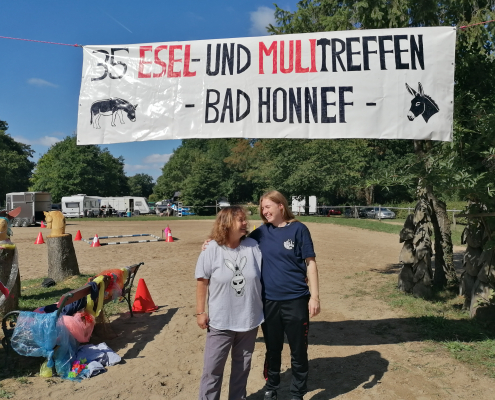 Foto: Zwei Frauen unter dem Schild zum Eseltreffen in Bad Honnef 2025
