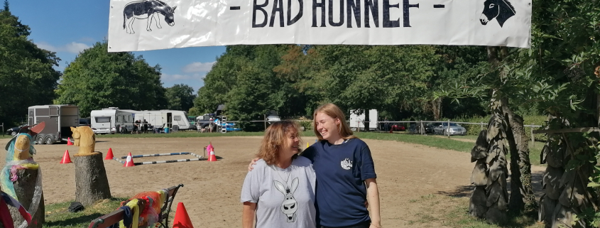 Foto: Zwei Frauen unter dem Schild zum Eseltreffen in Bad Honnef 2025